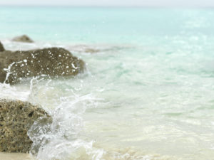 A crystalline sea splash onto the Bimini shore, The Bahamas.