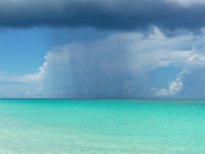 Rain shower over the white and blue beaches of Bimini, The Bahamas.