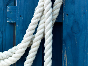 Caribbean colored blue fence contrasted with draped dock lines, The Bahamas.